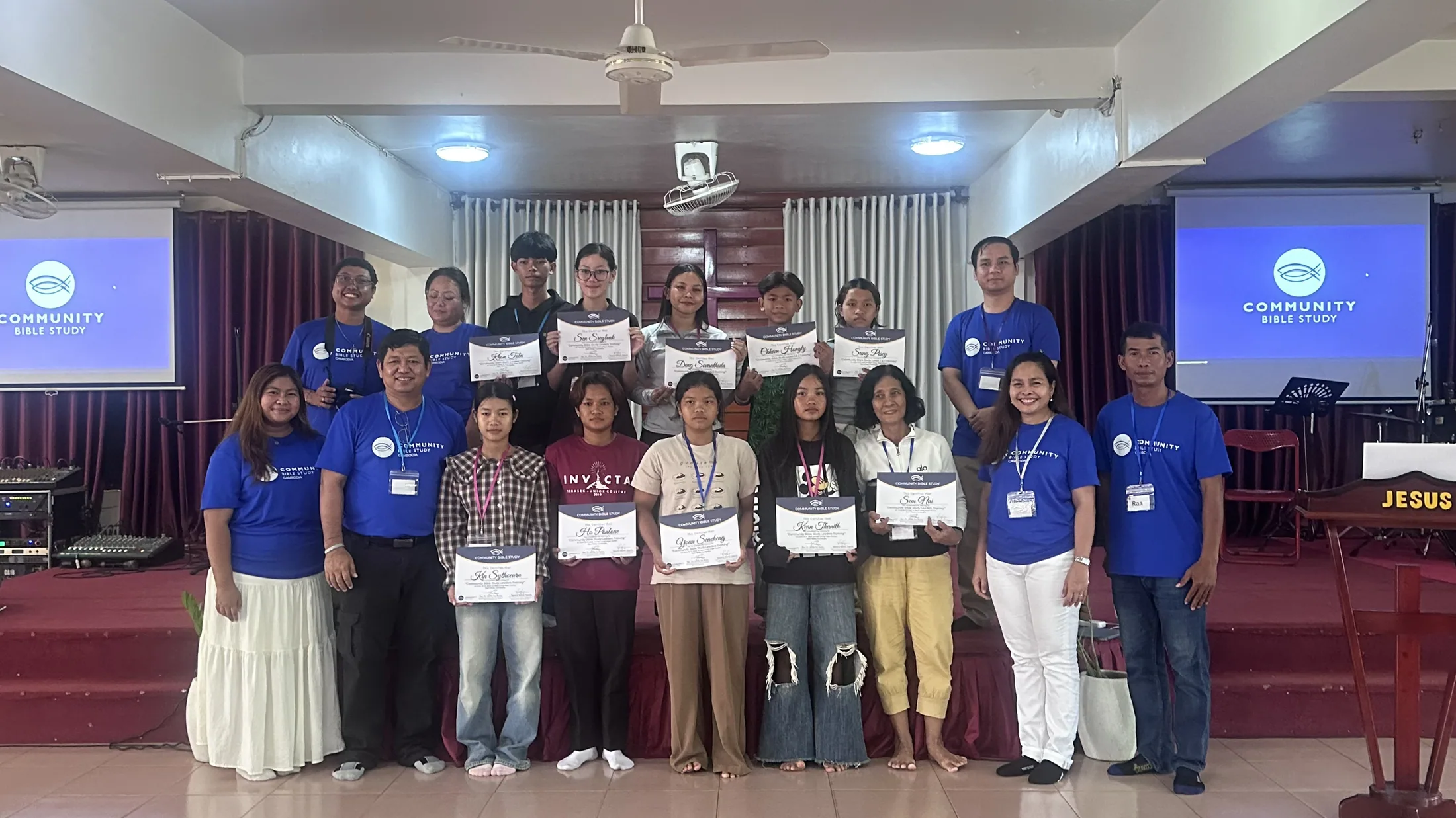 Community Bible Study participants holding certificates after training
