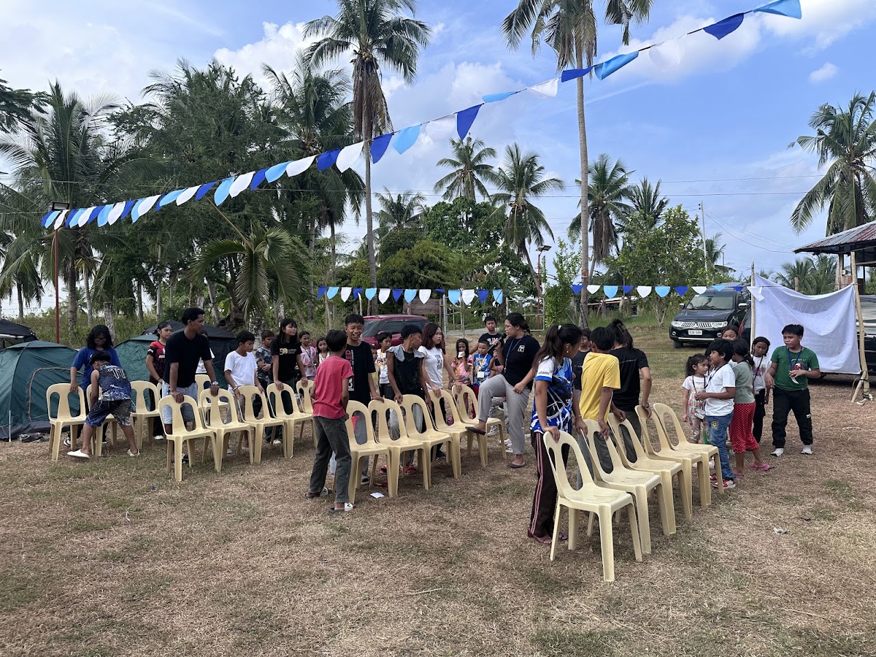 Children and adults gathered among chairs outdoors at Mt. Moriah